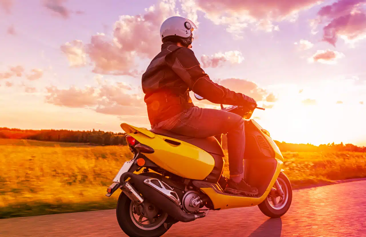 Scooter 125 in marcia su strada al tramonto